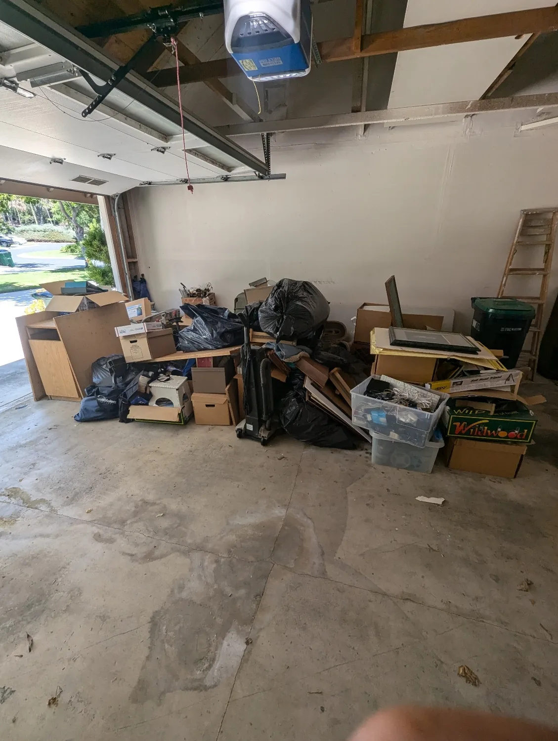 Cluttered garage full of junk before cleanout in Orange County, CA