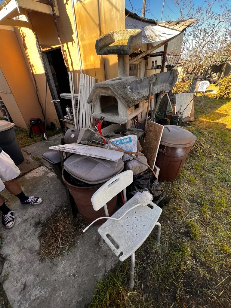 Yard full of accumulated furniture and junk cleared in Orange County, CA