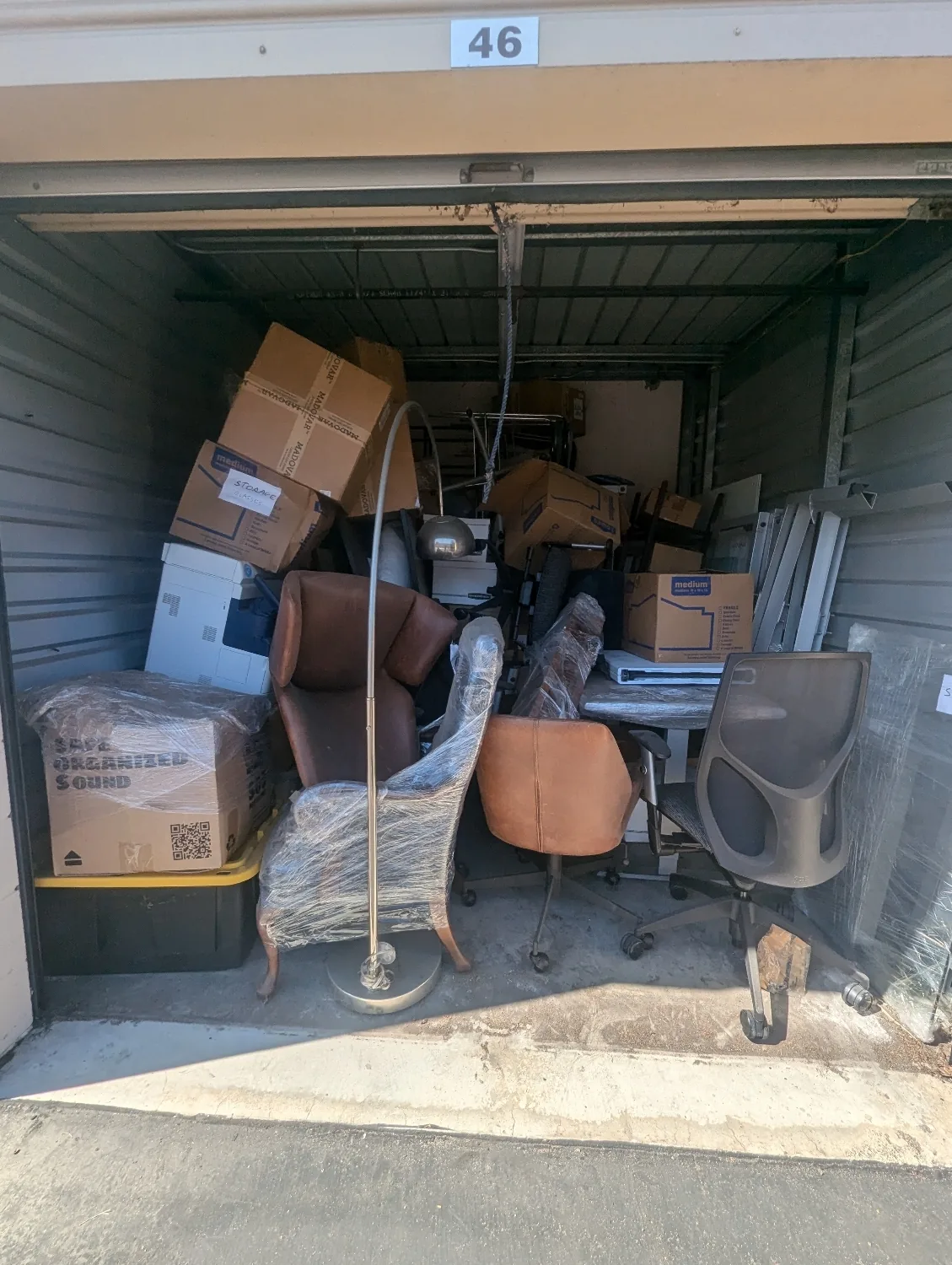 Storage unit packed with boxes and furniture before cleanout in Orange County, CA